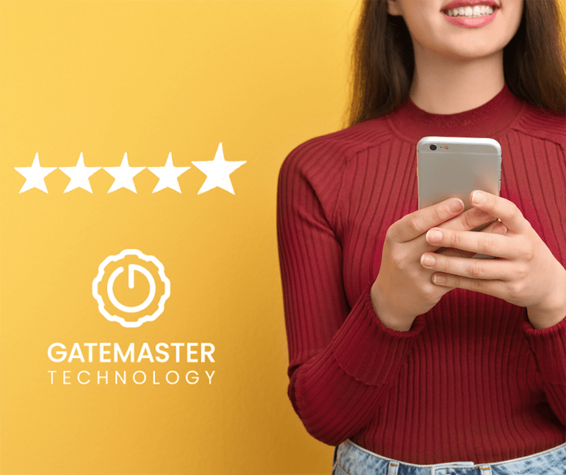 woman smiling and holding here phone while standing next to the gatemaster logo with a 5 star rating
